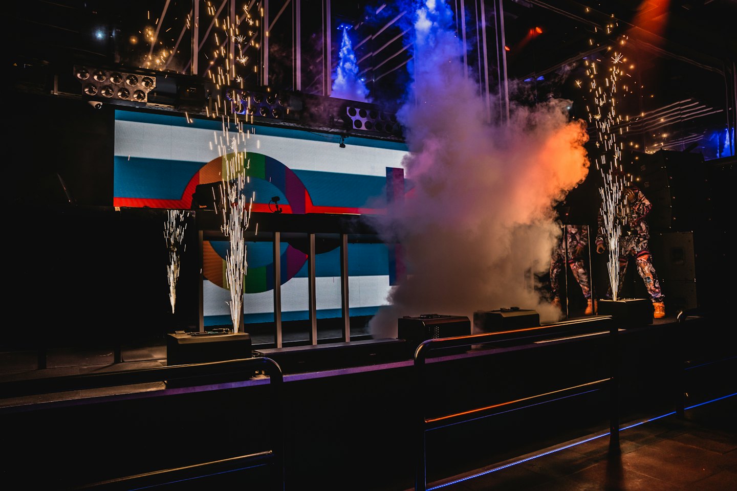 Pyrotechnic sparks erupt on a stage during a concert.