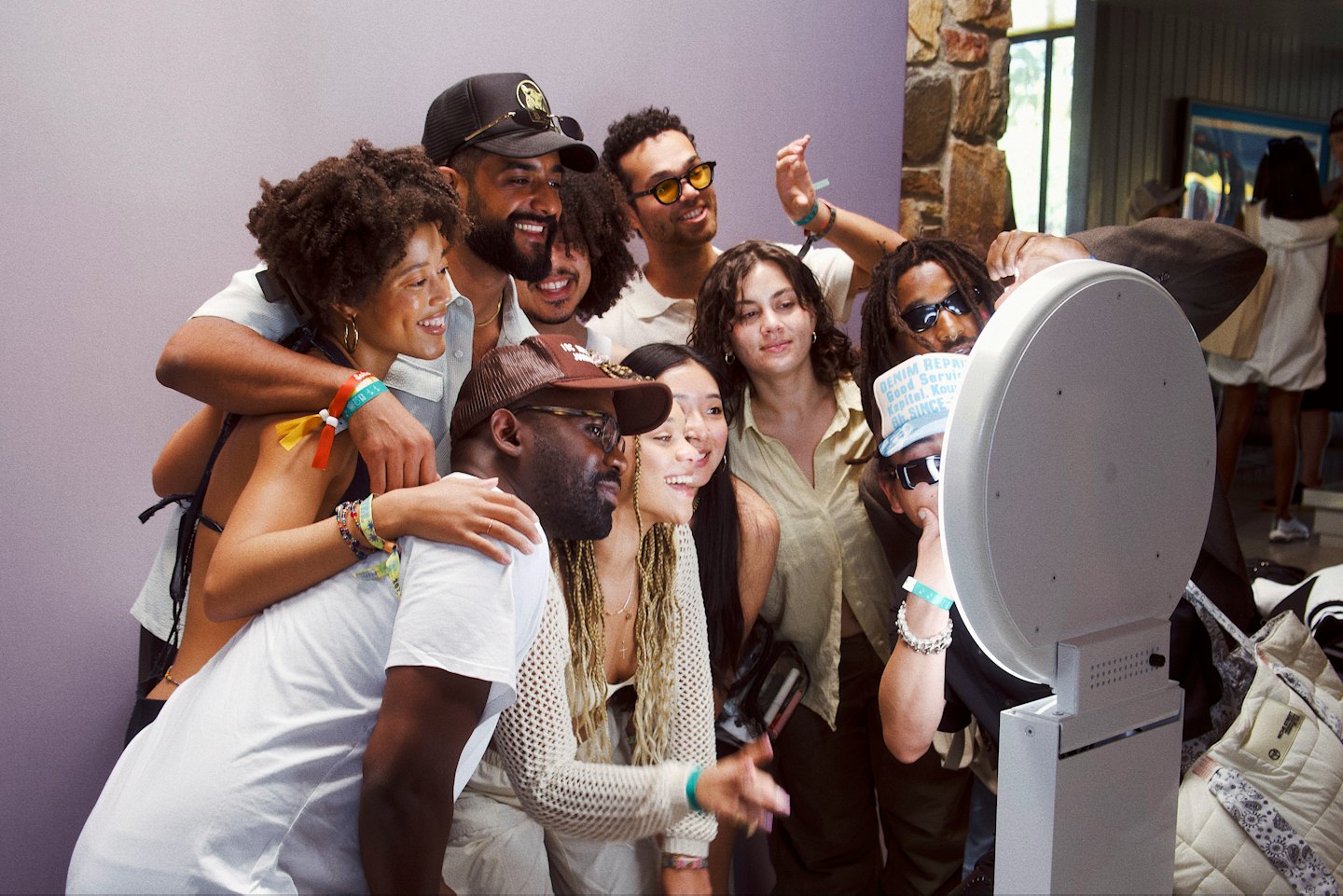 Group of young adults smiling in a photo booth at an event.